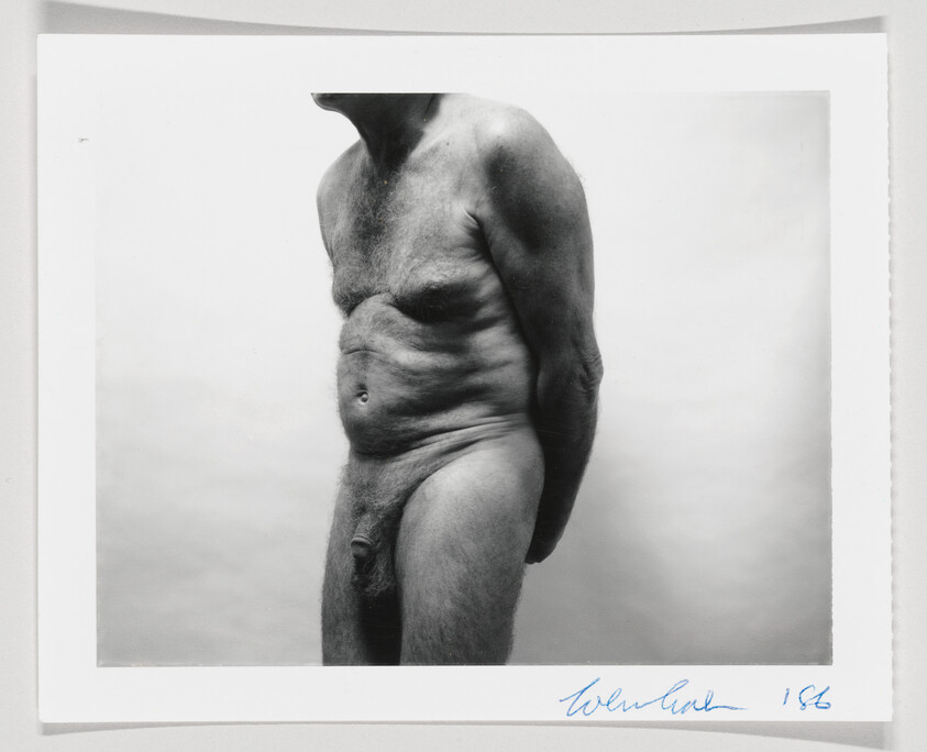 A man's nude body is shown slouching from just below the neck to right above the knee.