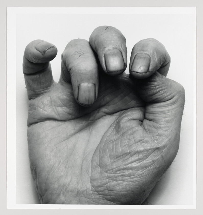 A white palm with fingers curling inward in black and white