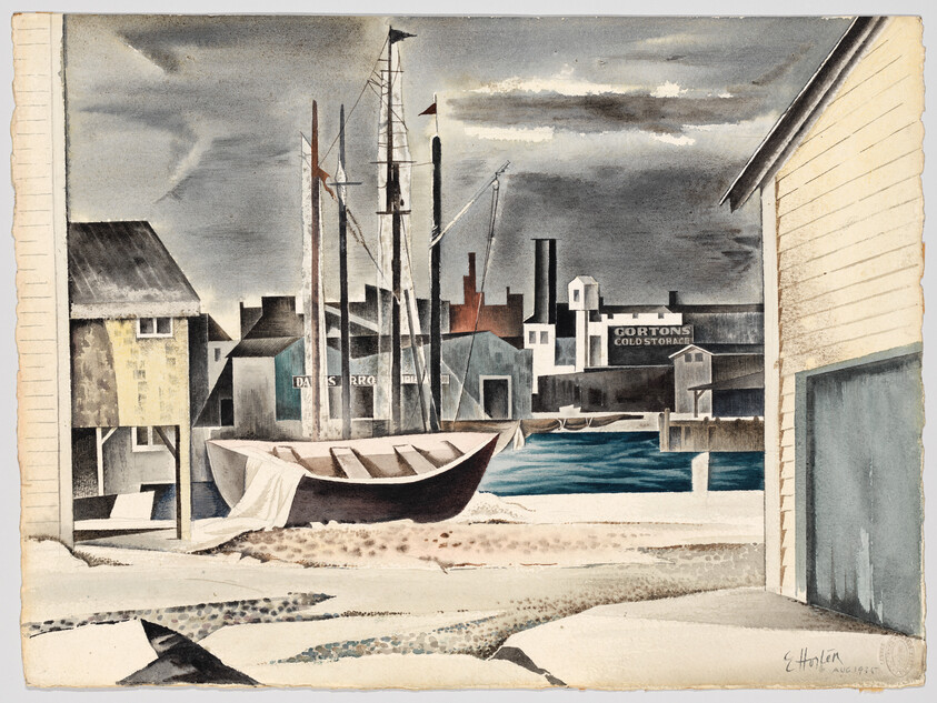 A small wooden boat rests on a sandy harbor shore with fishing piers and warehouses beyond.