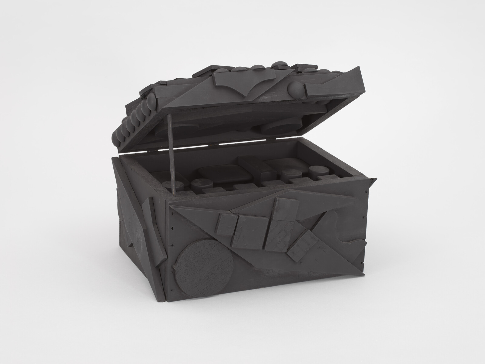 A black box with its lid open, covered in various geometric shapes and patterns on all sides.