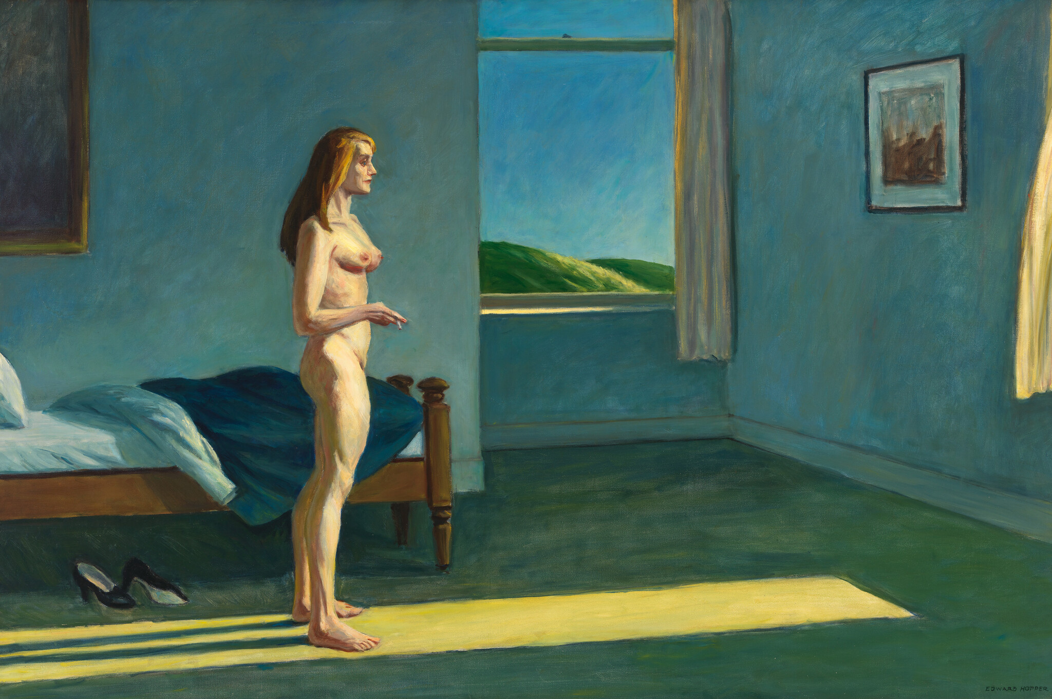 A nude white woman stands in a bluish bedroom and looks out a window as she holds a cigarette.