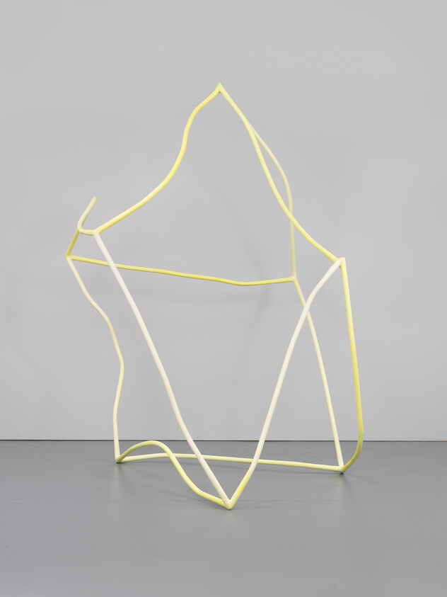 A pale yellow and white wire-frame sculpture with flowing geometric shapes standing on a gray floor.