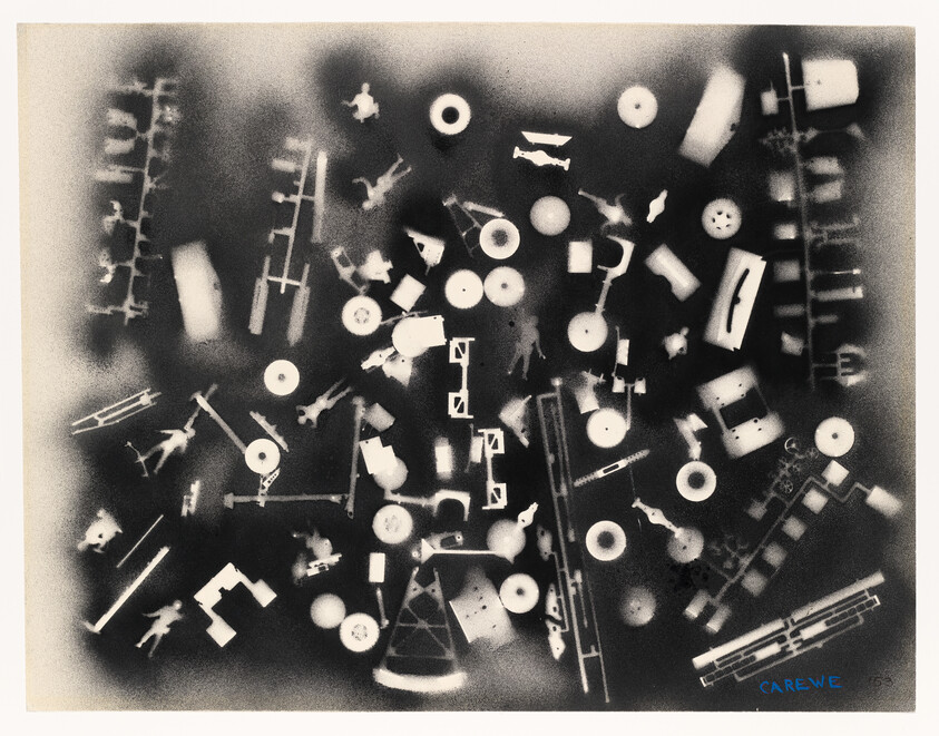 Scattered white silhouettes of toy parts and small figures arranged on a dark background.