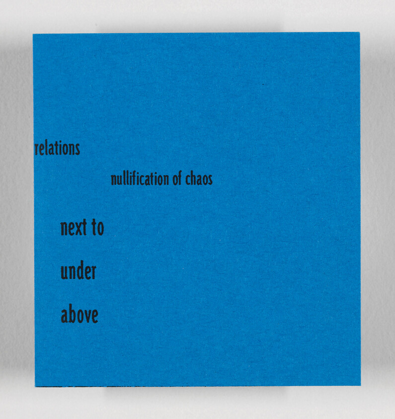 A blue card with black text printed in a scattered layout, featuring the phrases "relations," "nullification of chaos," "next to," "under," and "above." The card is placed on a white surface.