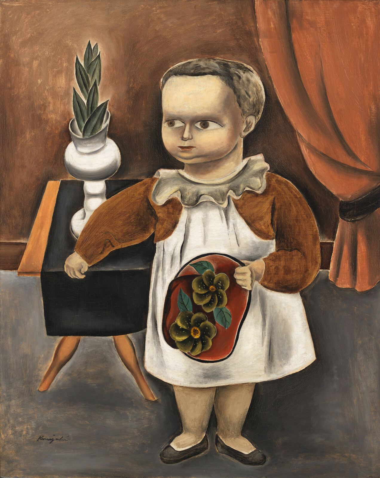 Child in a white apron holds a tray with flowers, standing beside a table with a plant.