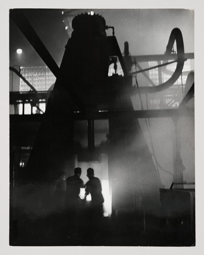 Three silhouetted factory workers stand near a glowing furnace amid smoke and machinery.