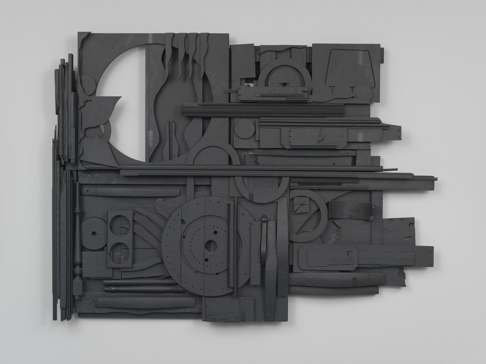 Abstract artwork with various black geometric shapes and textures arranged on a flat surface.