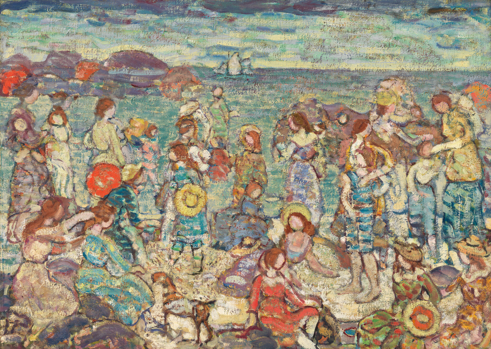 Crowd of people socializing and relaxing on a busy beach near the sea with a distant sailboat.