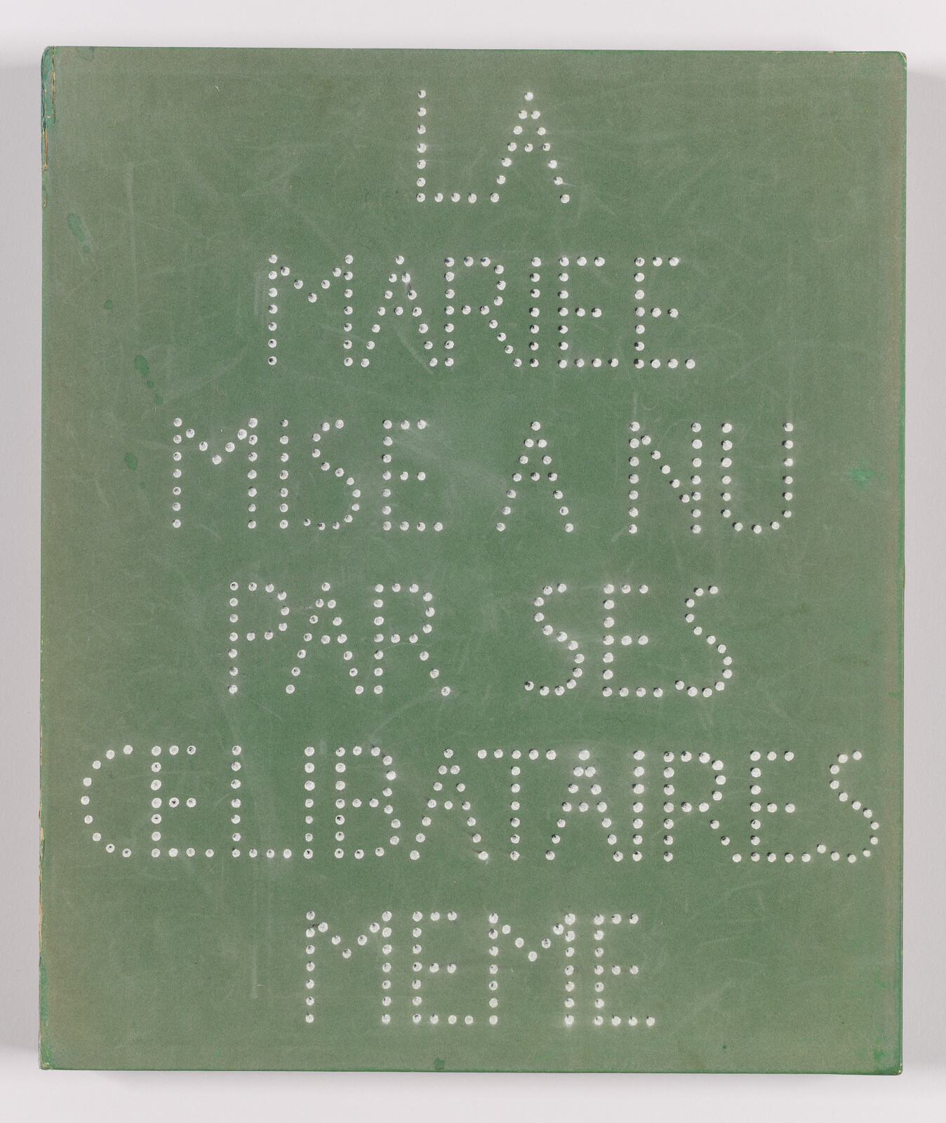Green board with pierced holes forming the French phrase "La marée mise à nu par ses célibataires même."