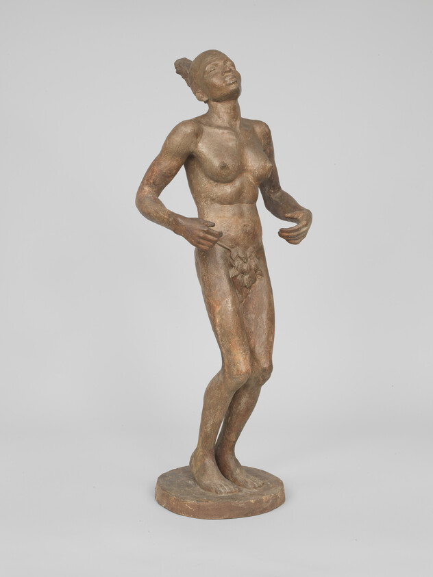 Bronze sculpture of a standing person with arms slightly raised, looking upward.