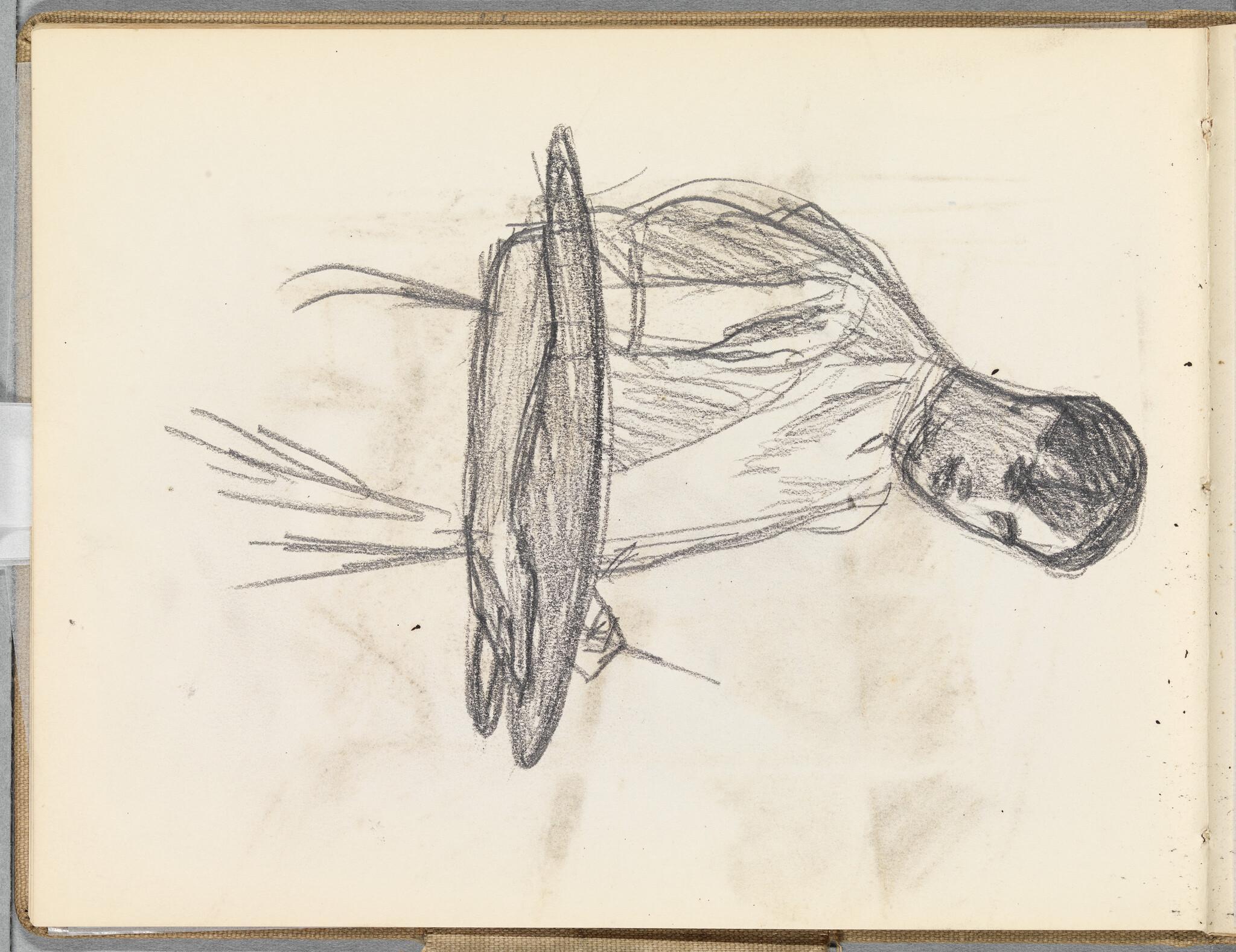 Man leaning over a round tabletop with his arms resting and head turned down.