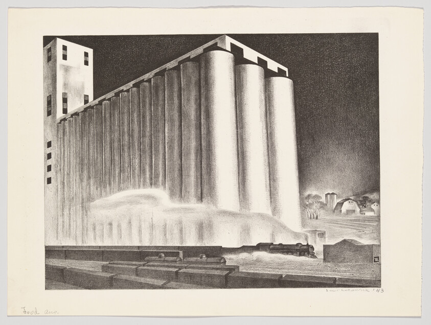 Large grain silos at night with steam or dust billowing and a train alongside.