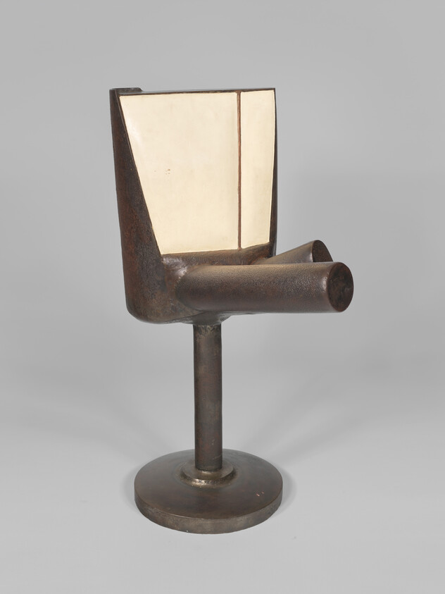 Small metal abstract chair sculpture with cylindrical armrest and cream-colored back panel on pedestal.
