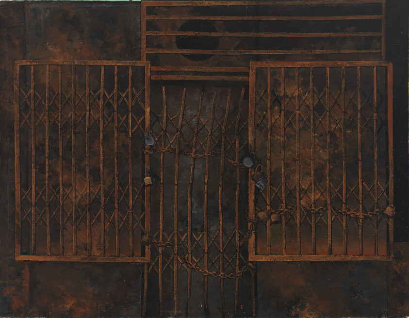 Rusty folding metal gates secured with chains and padlocks against a dark wall.