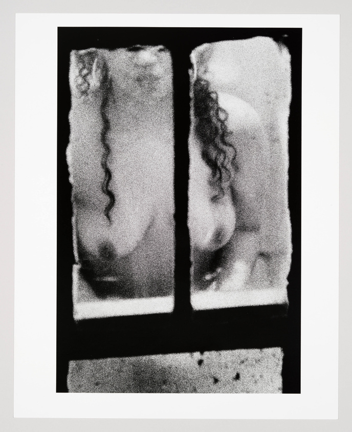 A grainy image seen from a window shows a nude woman's breasts