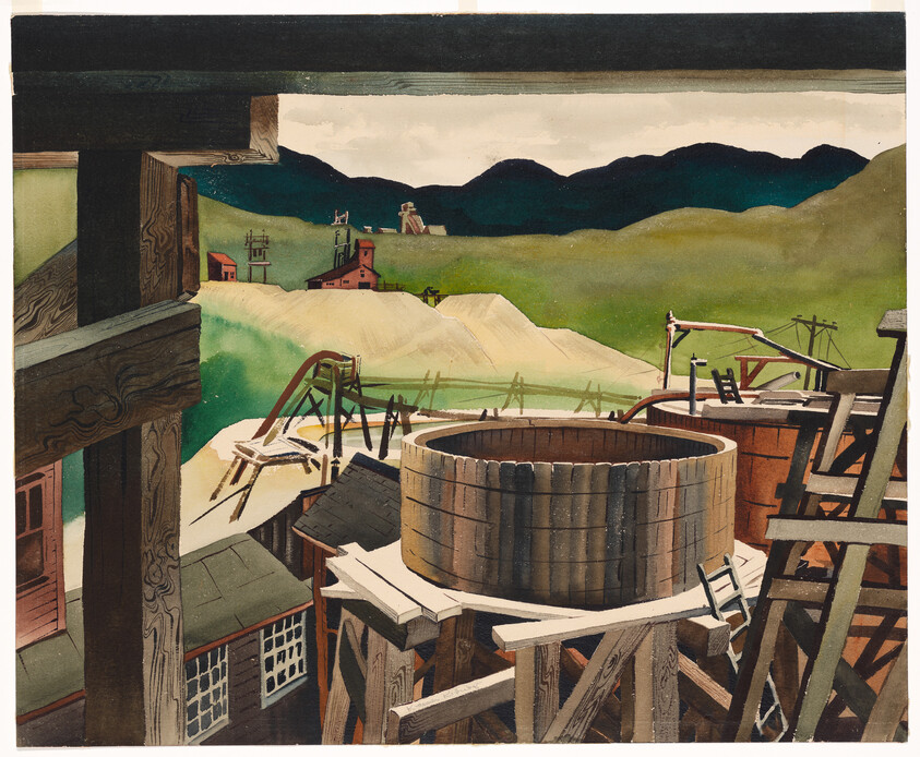 A large colorful textile wall hanging with soft sculptural elements displayed in a bright gallery corner.