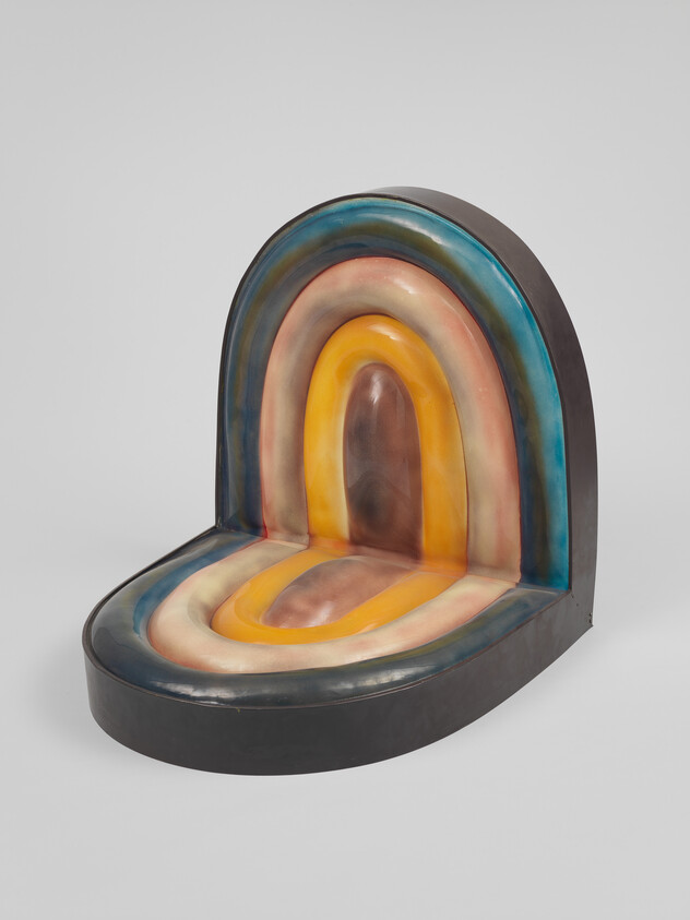 Curved sculptural seat with concentric rainbow-colored arches in muted blue, pink, orange, and brown.