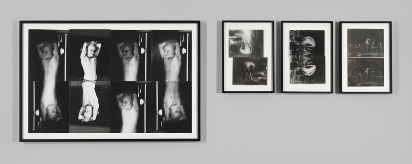 A gallery wall featuring a series of framed black and white photographs. On the left, a large frame contains a collage of images showing a shirtless man in various poses with his hands behind his head. To the right, three smaller frames display more abstract compositions, including blurred figures and dark, indistinct scenes that suggest movement and chaos. The artwork is presented in a clean, well-lit space, emphasizing the contrast between the stark photography and the minimalist setting.