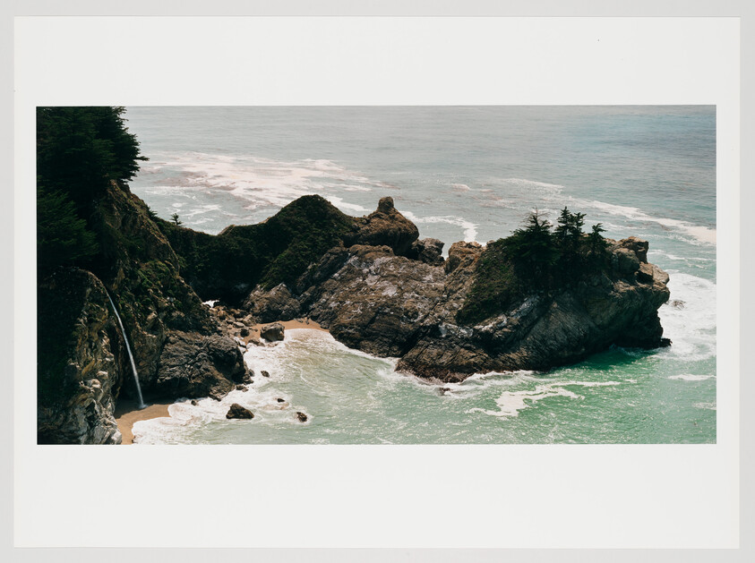 A scenic coastal view featuring a waterfall cascading down a cliff into a cove with turquoise waters surrounded by rugged rocks and greenery.