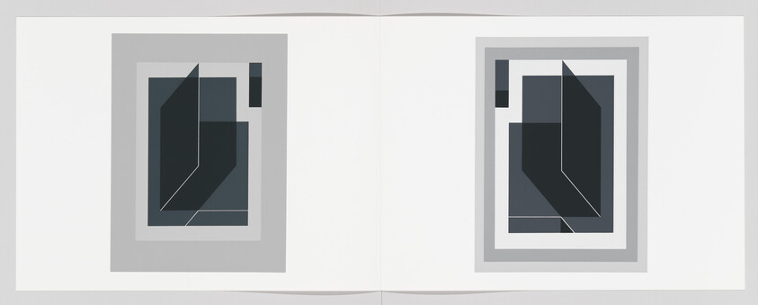 Two abstract geometric prints with dark layered shapes are displayed side by side on an open white book.