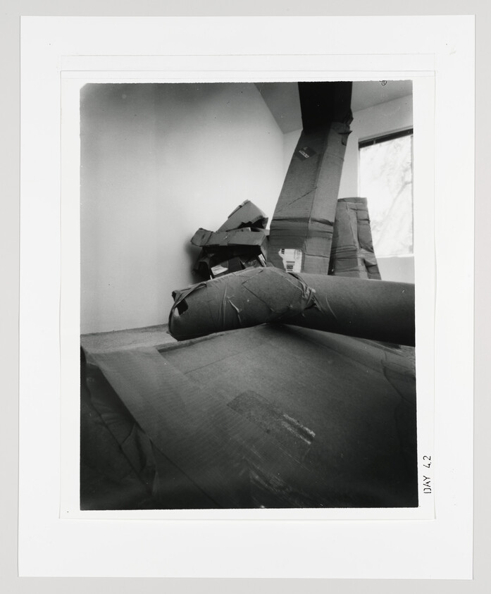 Large padded and wrapped cardboard forms stacked and leaning against the walls in an empty room.