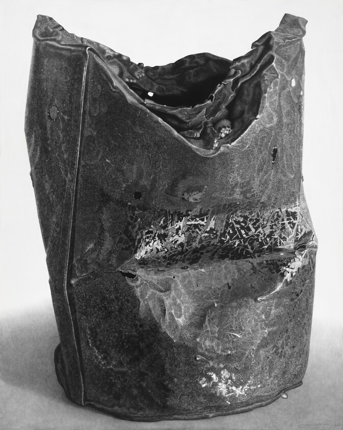 A crushed, rusted metal container with a torn top and scratched, pitted sides.