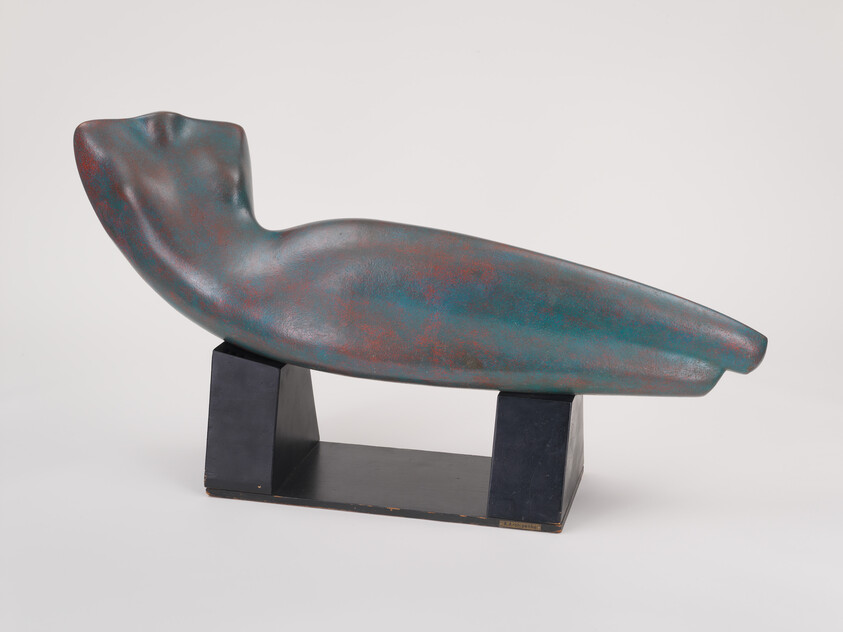 Abstract smooth teal-and-rust reclining form sculpture resting on a black rectangular base.