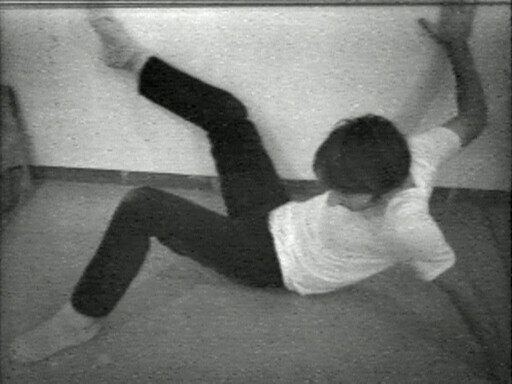 A person lies on the floor with one leg and one arm raised awkwardly.