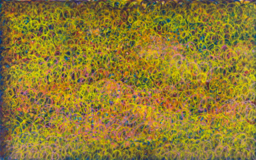 Dense field of overlapping neon rings in yellow, pink, and blue forming a vibrant abstract pattern.