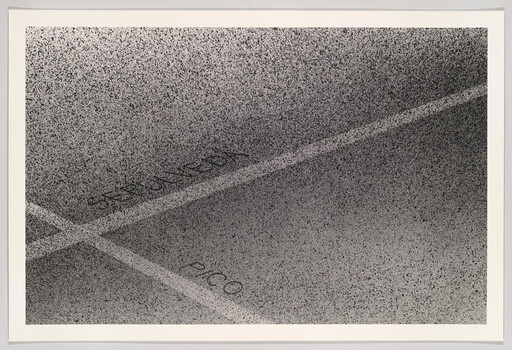 Parking lot pavement with painted lines and faded words reserved and pico.