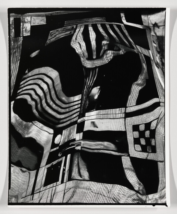 Distorted black-and-white reflection with wavy stripes and grid-like patterns on a surface.