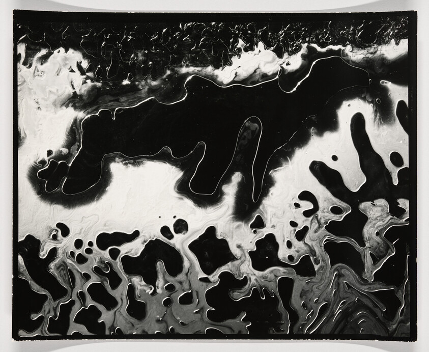 Black-and-white marbled fluid shapes flow across the frame like liquid ink patterns.