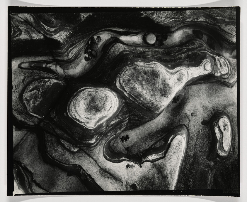 Swirling black-and-white abstract patterns resembling layered rock formations and rounded islands.