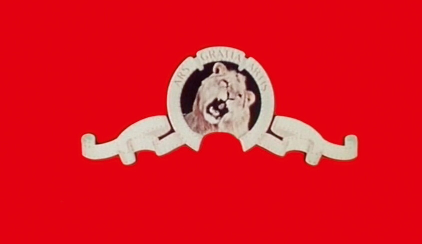A roaring lion emblem with a ribbon and the motto ars gratia artis on a red background.