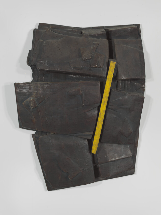 Dark textured wall sculpture of overlapping panels with a single vertical yellow bar.