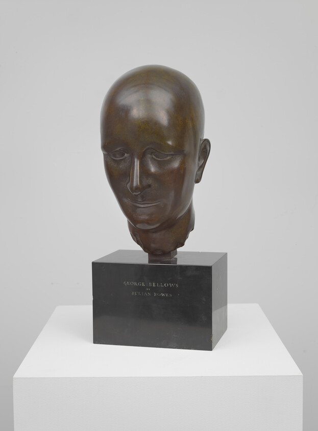 Bronze sculpted head displayed on a black plinth with engraved name on the base.