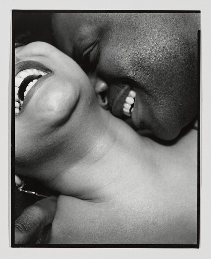 Two people are close together, smiling and laughing, showing joy and affection.