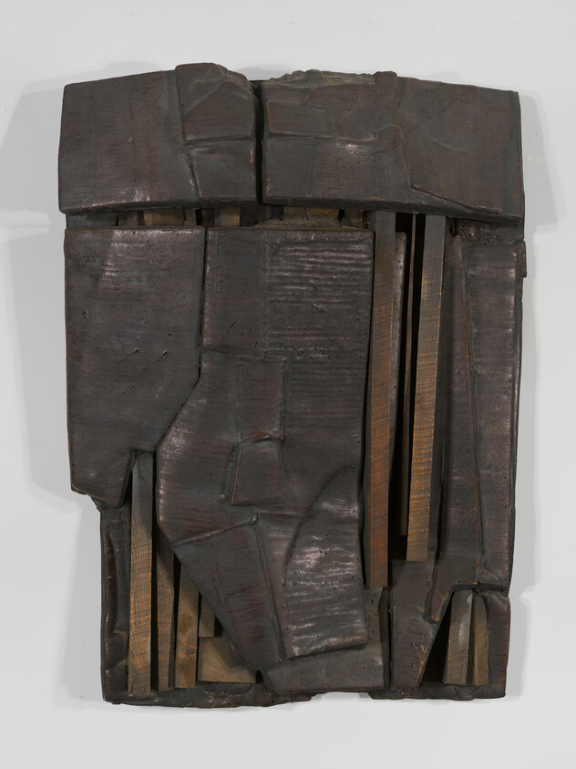 Dark wooden abstract relief sculpture with overlapping panels and visible vertical slats.