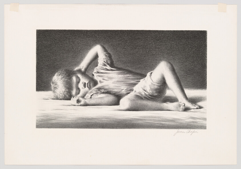 A young child lies curled on a bed, sleeping with one arm behind their head.