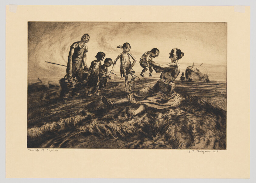 Mother sitting on a grassy hill lifts a baby while father and children approach across the field.