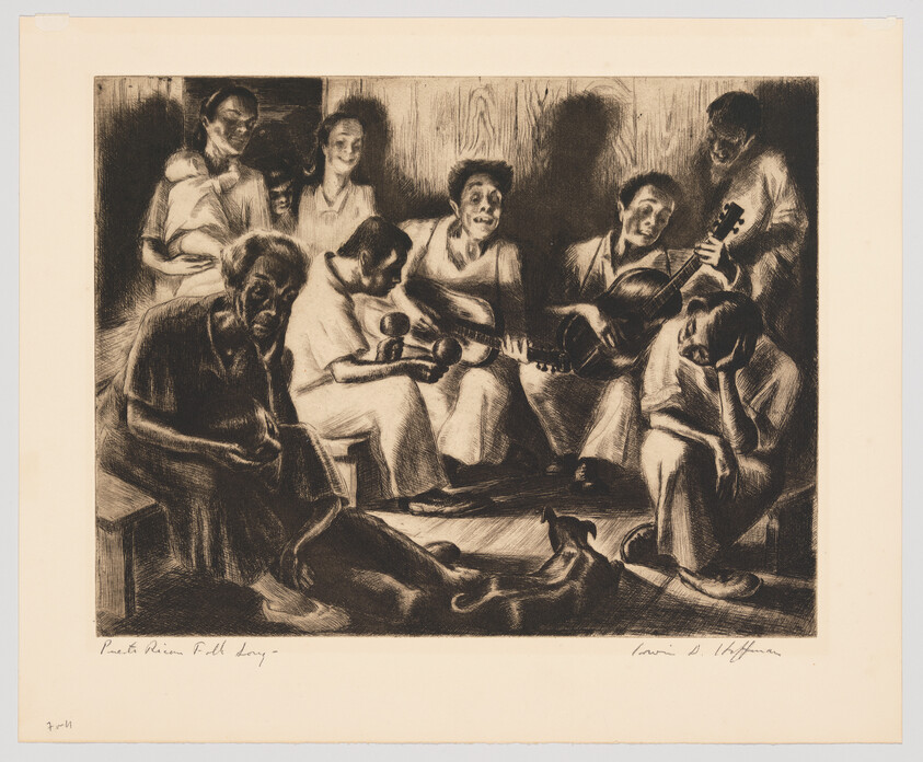 A group of people sit closely together singing and playing guitars while others listen quietly.