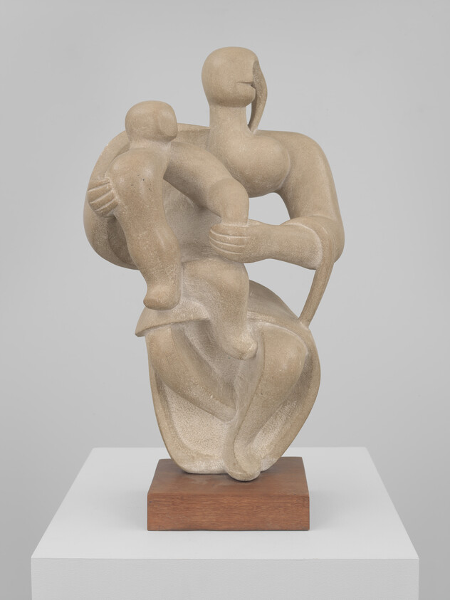 Abstract stone sculpture of a seated figure tenderly holding a child on a wooden base.