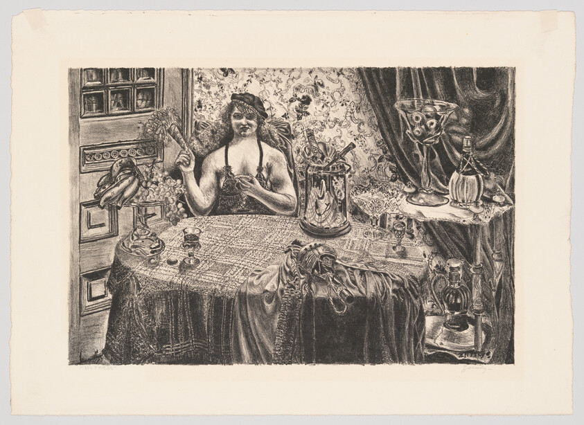 A woman sits at a cluttered table holding a fan and touching her chest amid bottles and draped fabric.