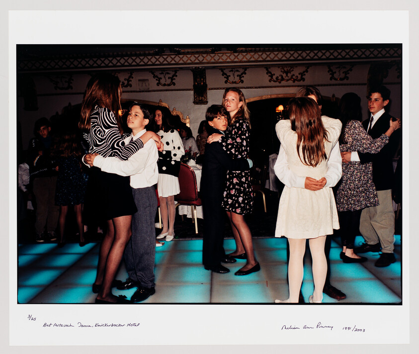 Young teens slow-dance in pairs on a glowing dance floor at a formal party.
