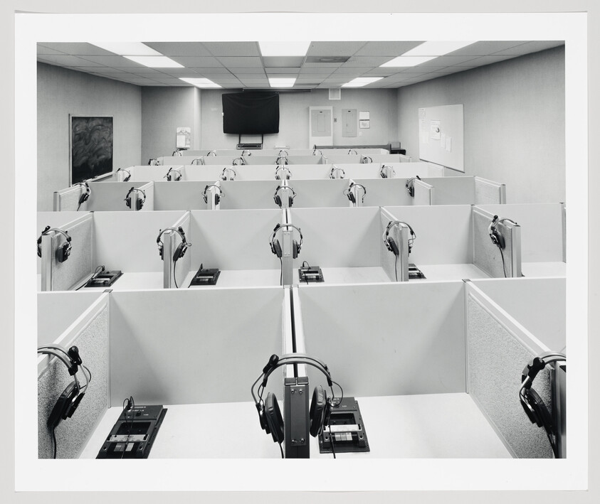 Empty testing cubicles with headsets and tape recorders arranged in neat rows.
