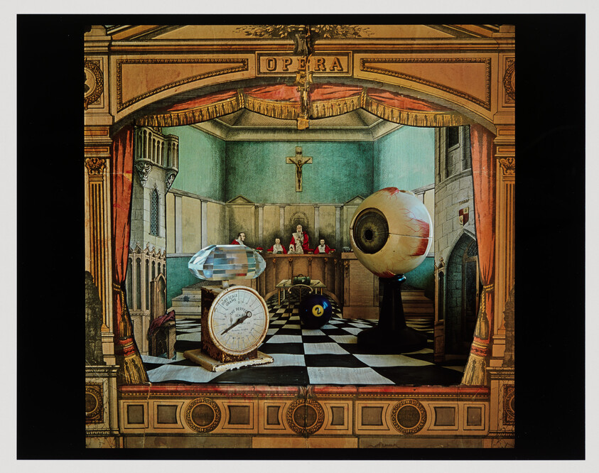 A theatrical courtroom scene with a giant eyeball on a pedestal and assorted objects.