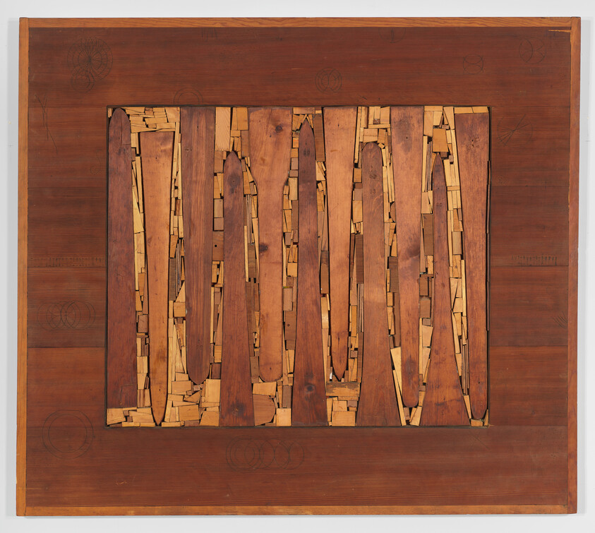 Rectangular wooden panel with vertical elongated cutouts filled with small irregular wood pieces.