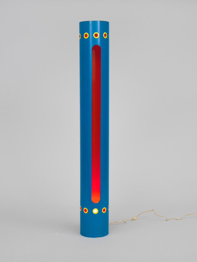 Tall blue cylindrical lamp with red glowing interior and decorative yellow dot accents.