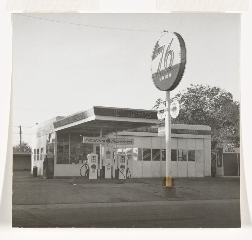 Vintage Union 76 gas station with fuel pumps and large circular 76 sign visible.