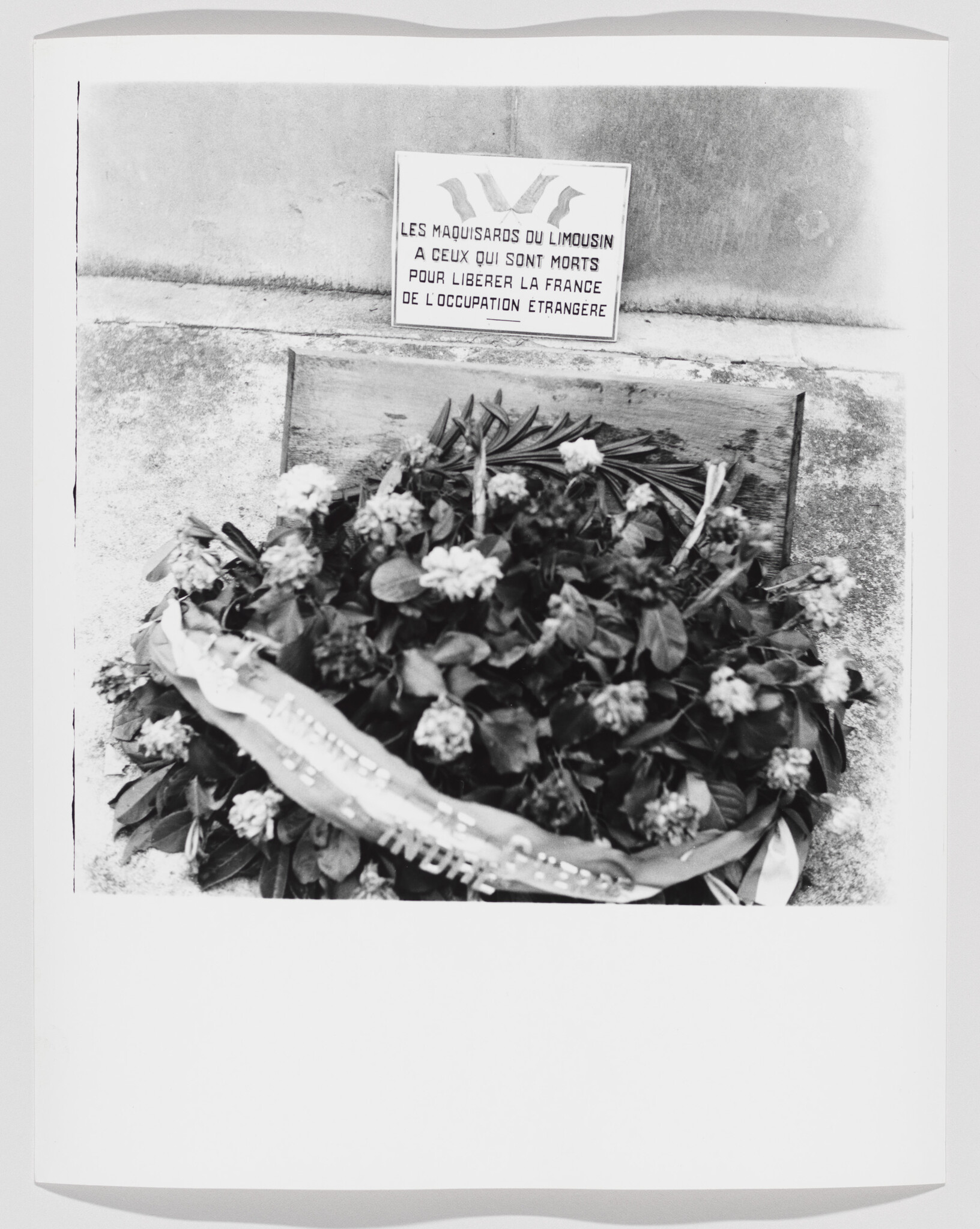 A wreath rests at a memorial plaque honoring Limousin resistance fighters who died freeing France.
